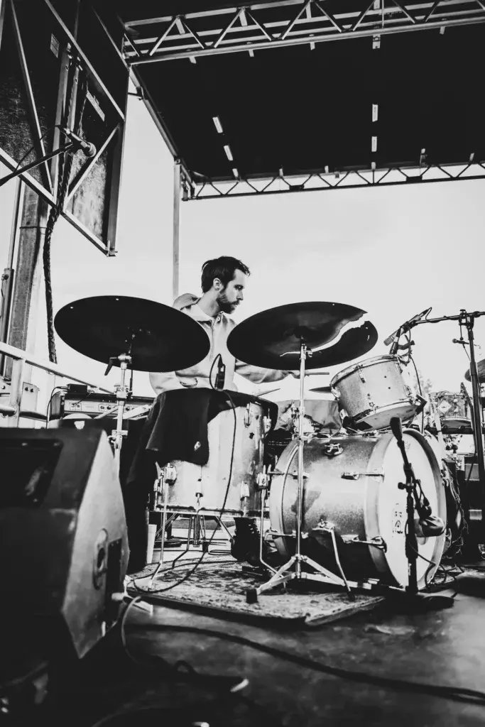 A drummer performs on stage at Dancing Rabbit Music Festival, captured in black and white.
