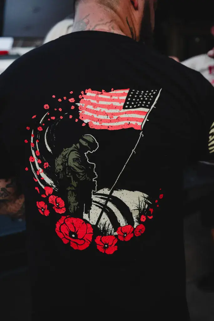 Close-up of a black t-shirt featuring an American flag and red poppies with a patriotic design.