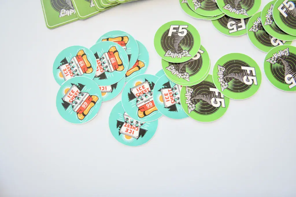 Collection of colorful round festival badges and stickers featuring hot dogs and music-themed designs.