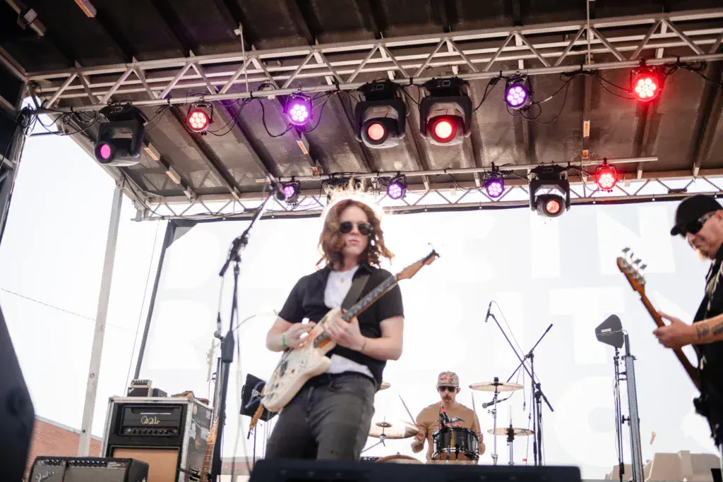Musicians perform on an outdoor stage with professional lighting at Dancing Rabbit Music Festival.