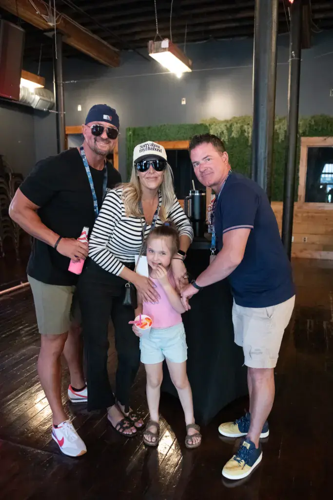 Four people posing together for a photo inside a venue at the Dancing Rabbit Music Festival.