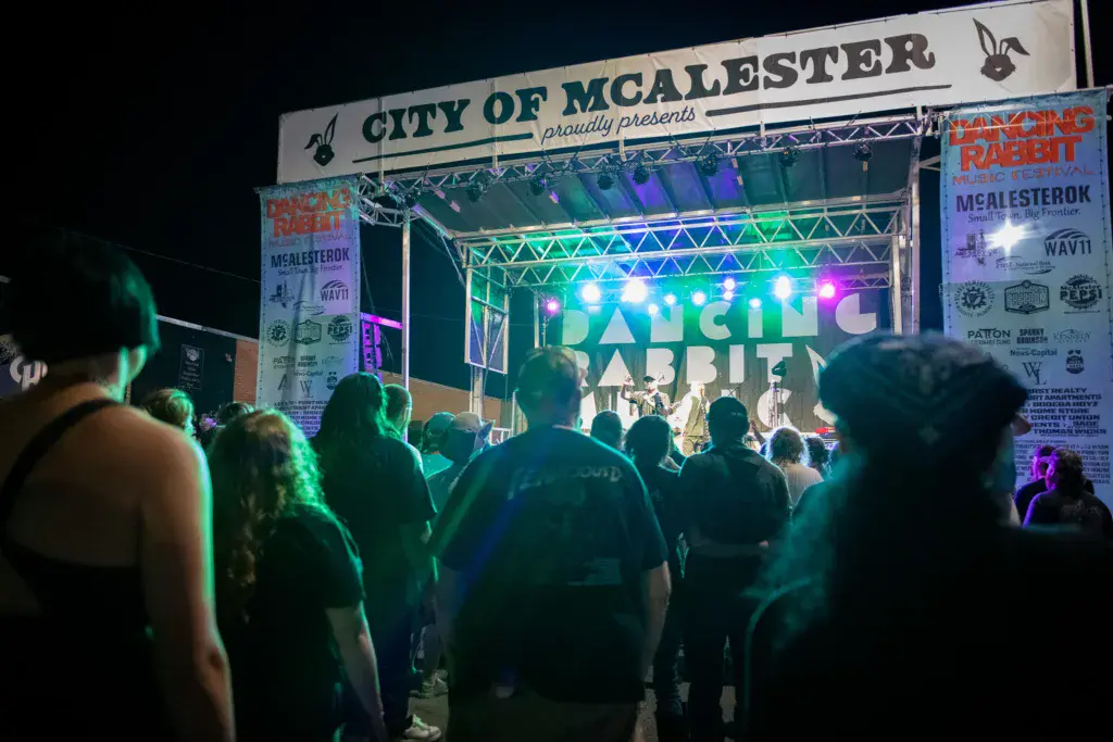 Crowd watches a band perform on an illuminated stage at the Dancing Rabbit Music Festival in McAlester.
