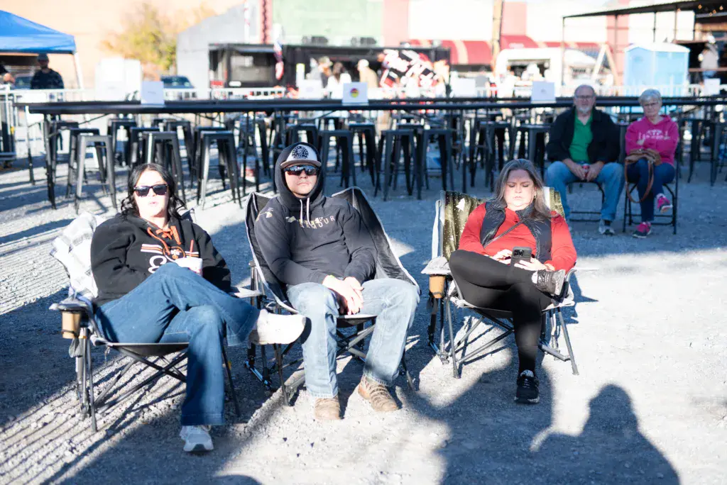 Festival attendees sitting in lawn chairs watching the performance at an outdoor music event.