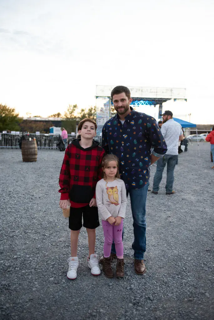 An adult and two children pose together at the Dancing Rabbit Music Festival grounds.