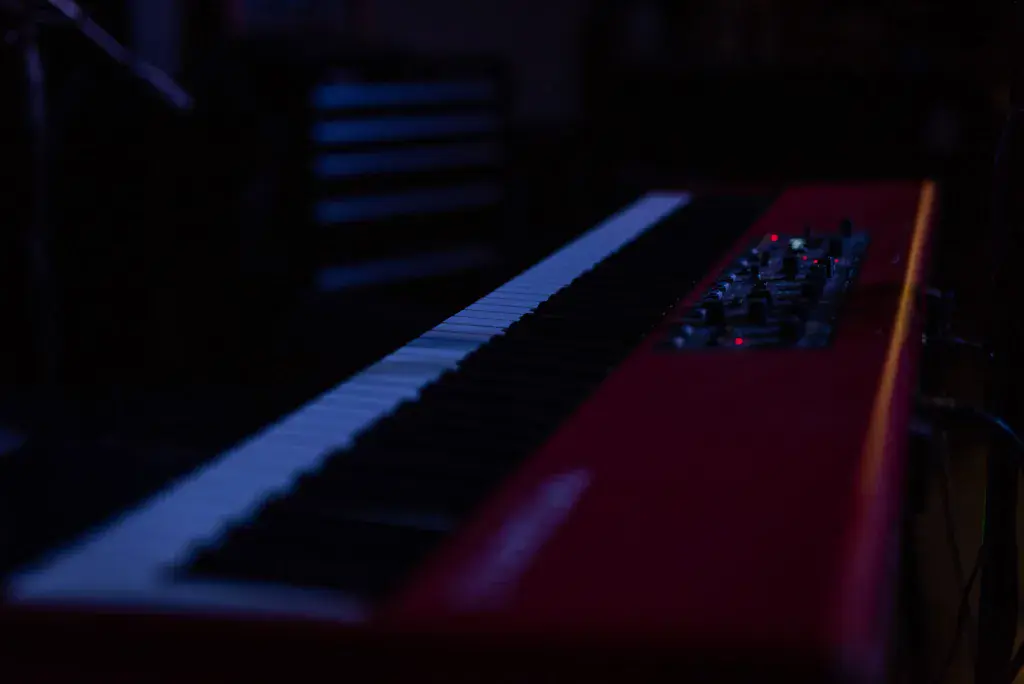 Close-up detail of musical instruments on stage lit with blue and red stage lighting.