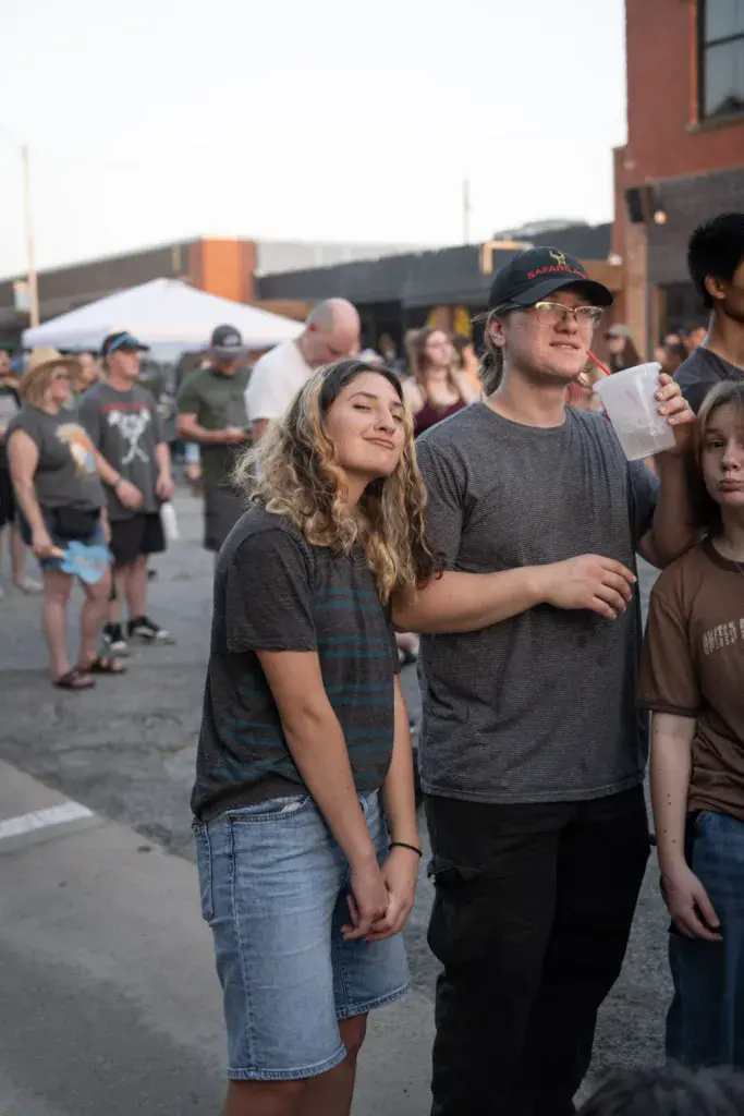 Festival attendees watching a performance at an outdoor venue during golden hour.
