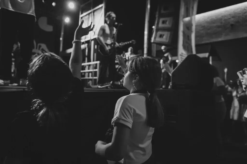 Crowd members watch a band perform on an illuminated stage at night during the festival.